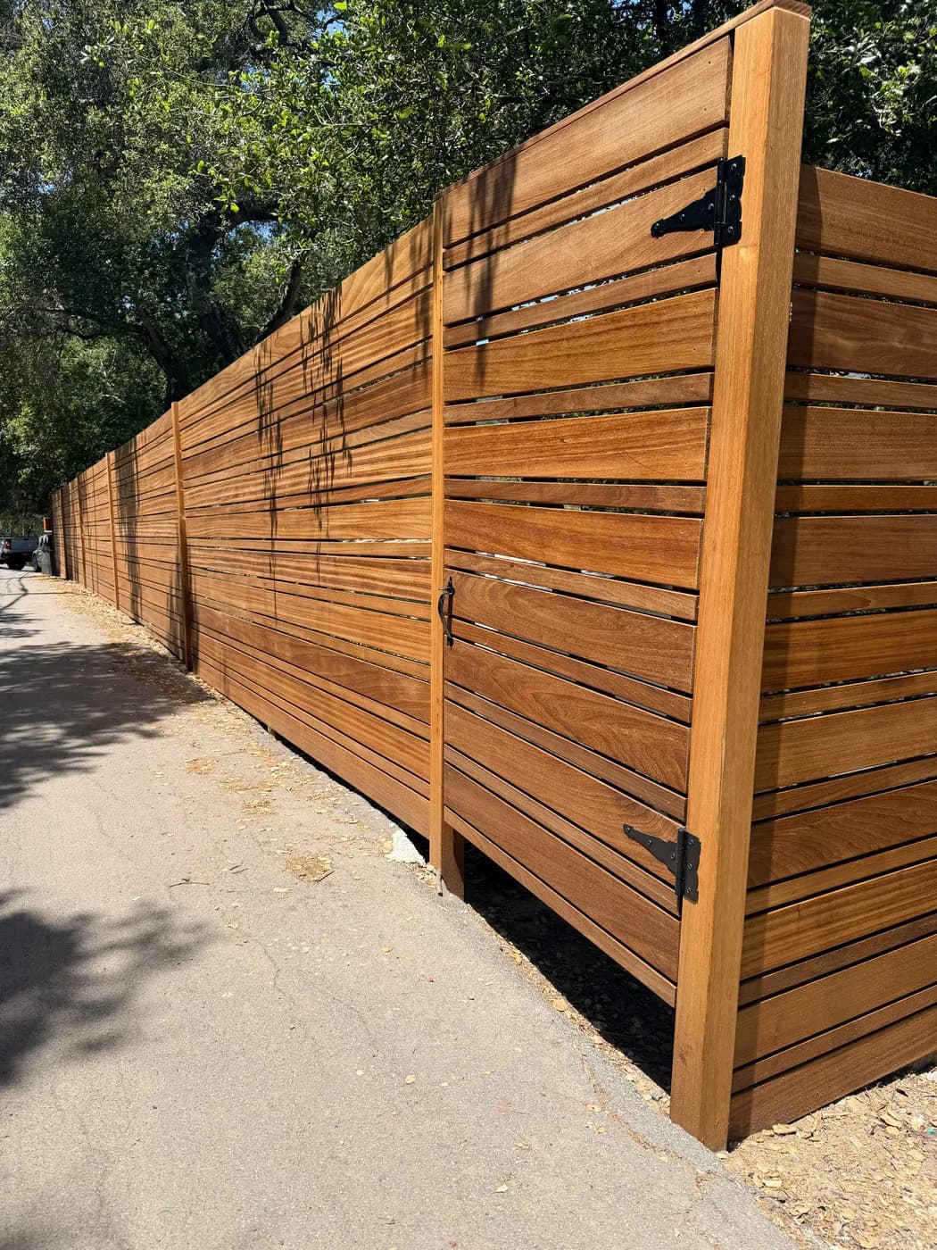 Side angle view of a horizontal wood privacy fence and gate