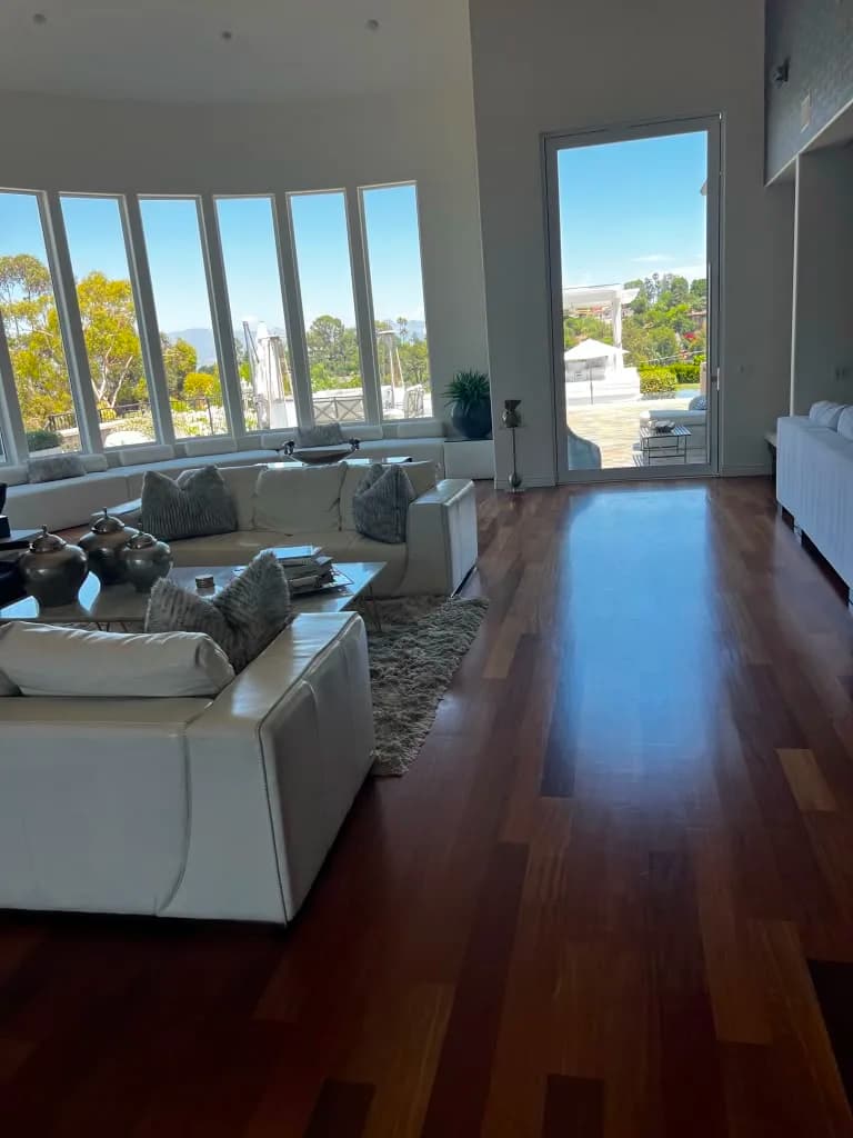 Living room seating area with view to pool patio by Top Tech Builders