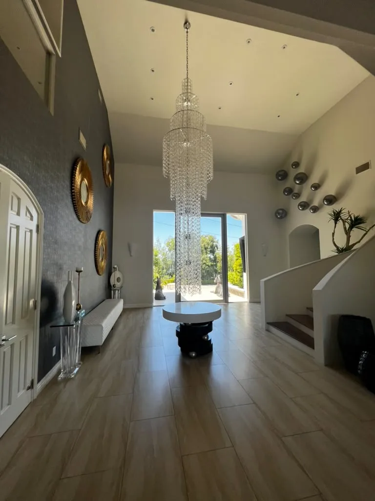 Entry foyer with chandelier and tile flooring by Top Tech Builders