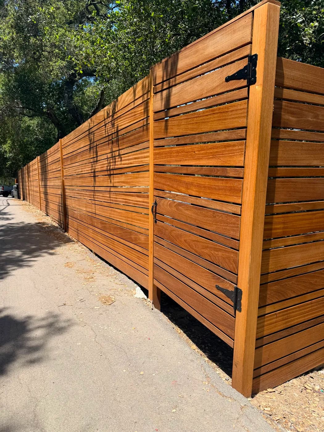 Wood slat privacy fence and gate by Top Tech Builders