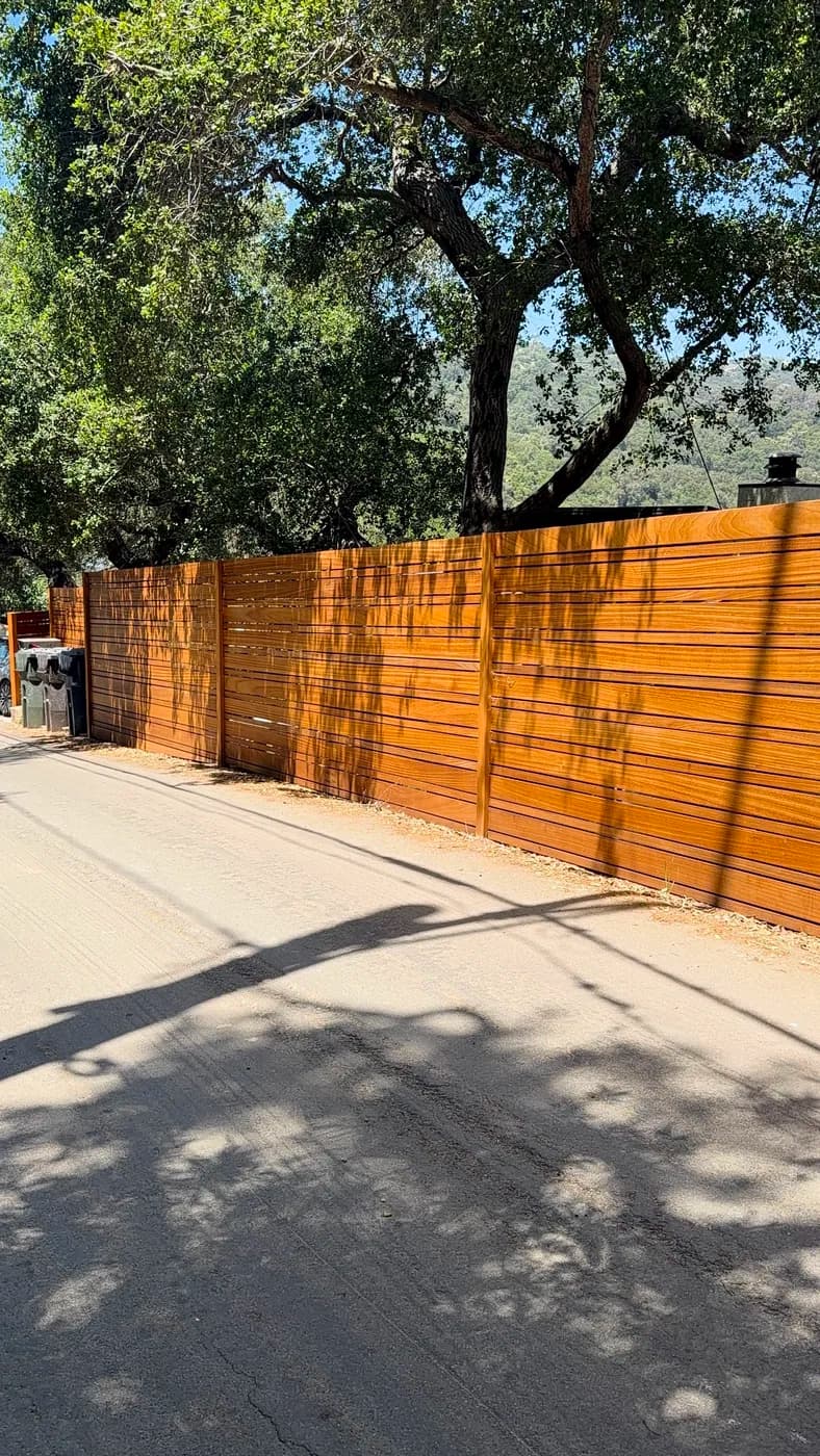 Wood slat fence installation by Top Tech Builders