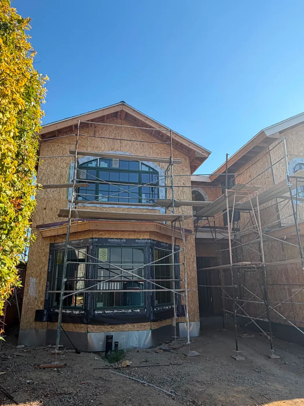 Home exterior framing with arched windows by Top Tech Builders