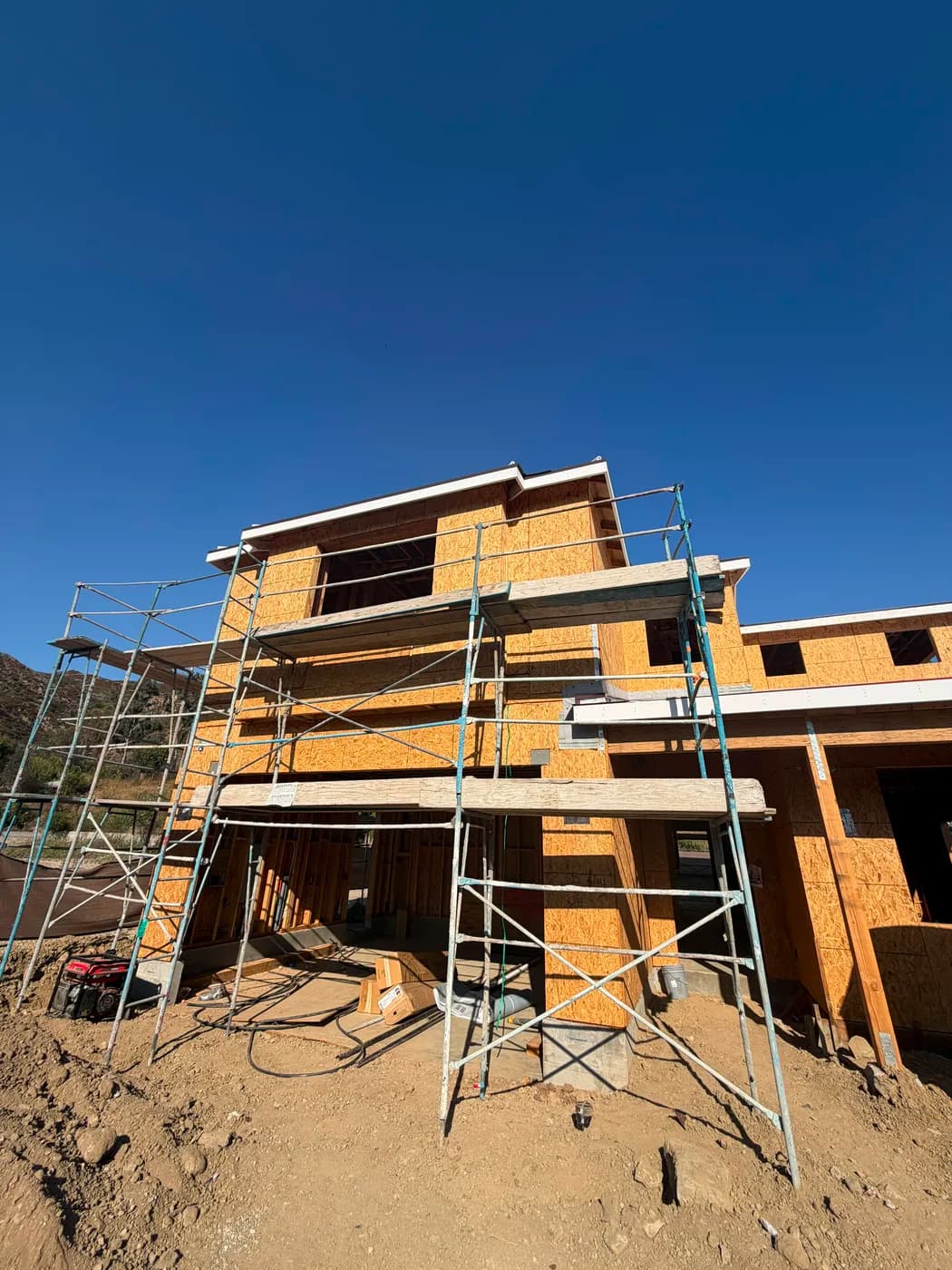 Two-story home framing with scaffolding by Top Tech Builders