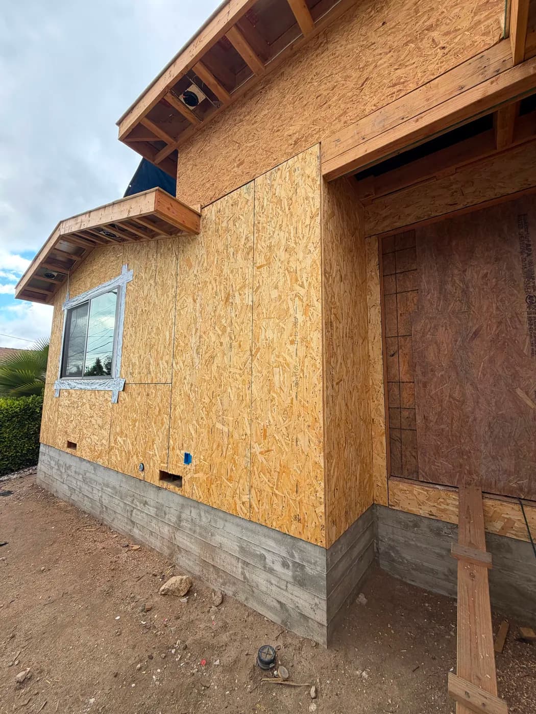 Exterior wall framing and window installation by Top Tech Builders