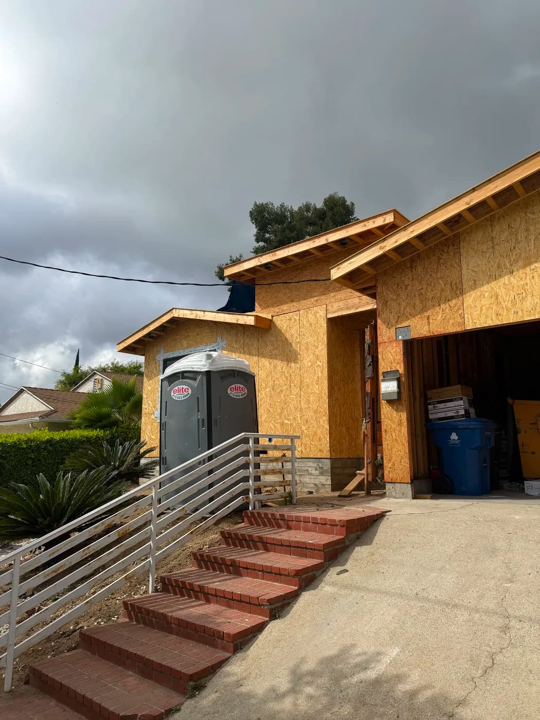 Whole-home remodel exterior progress by Top Tech Builders