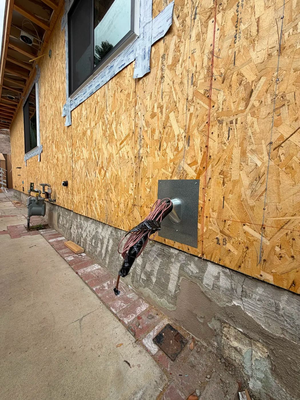 Exterior wall sheathing and window flashing on home addition by Top Tech Builders
