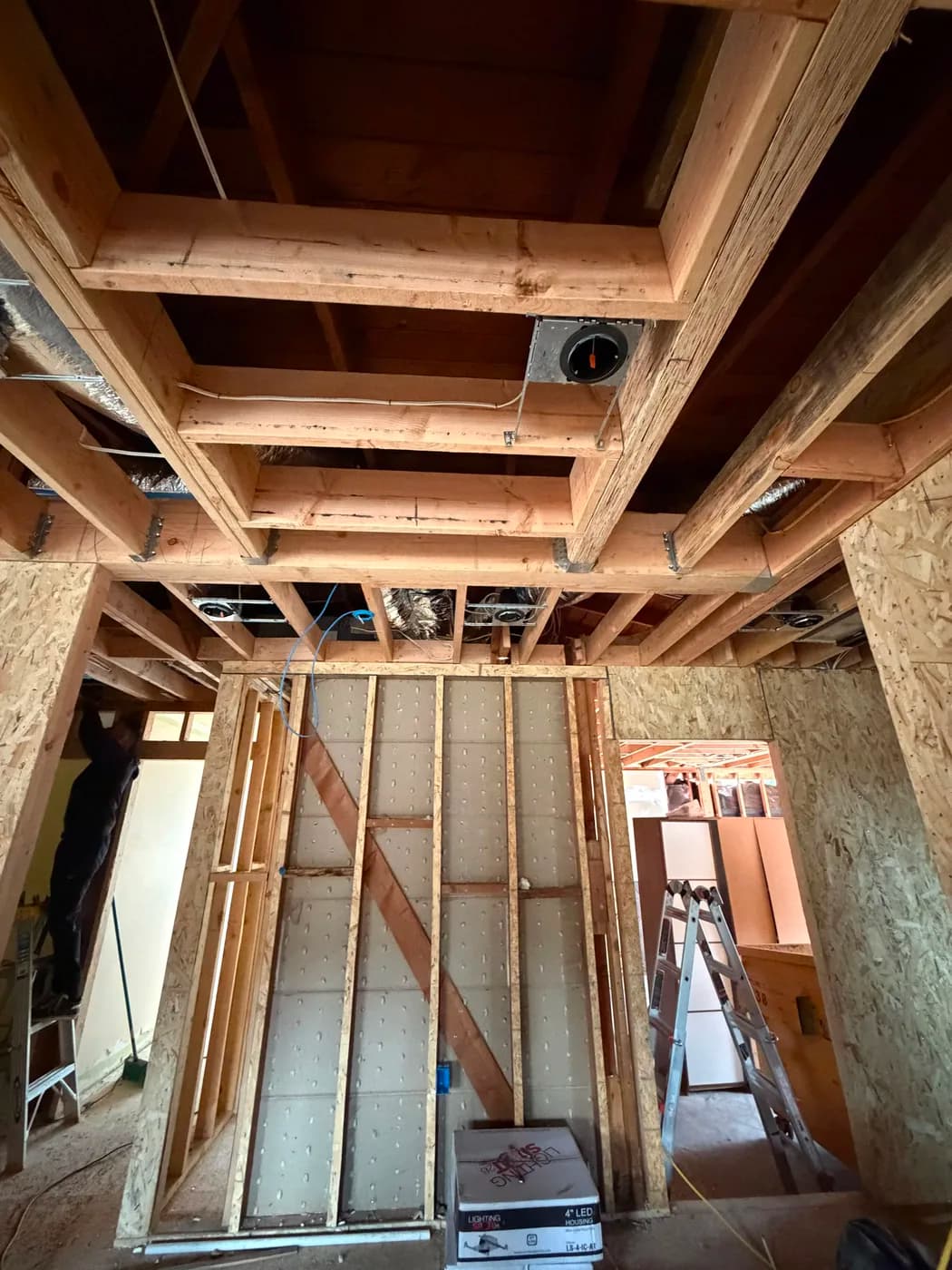 Ceiling joist framing and insulation board wall by Top Tech Builders