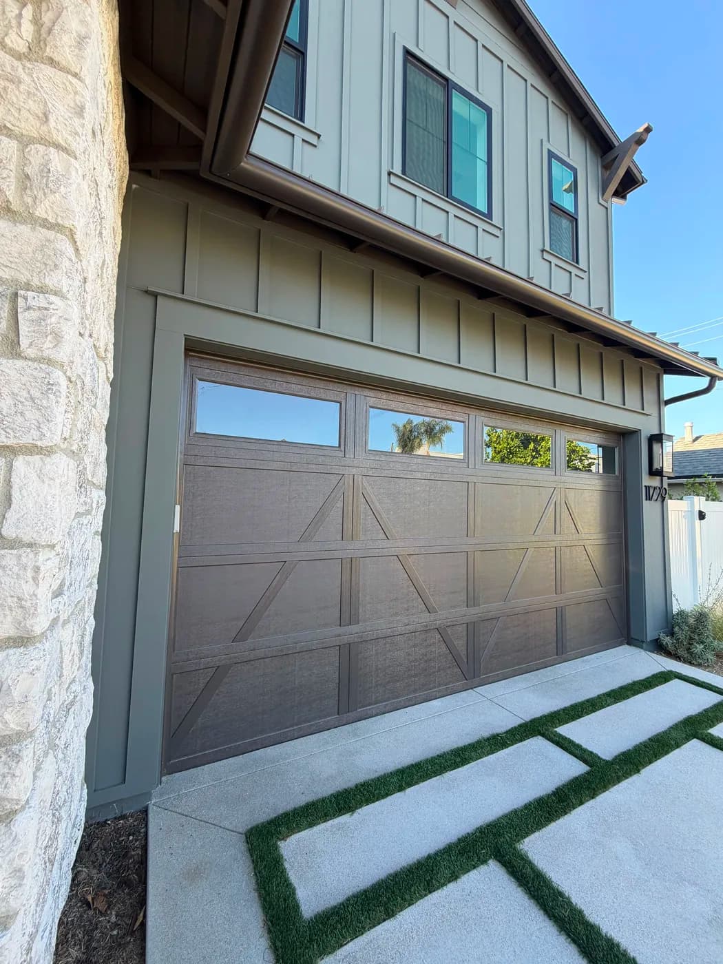 Close-up of turf-inlaid paver driveway and garage entry by Top Tech Builders