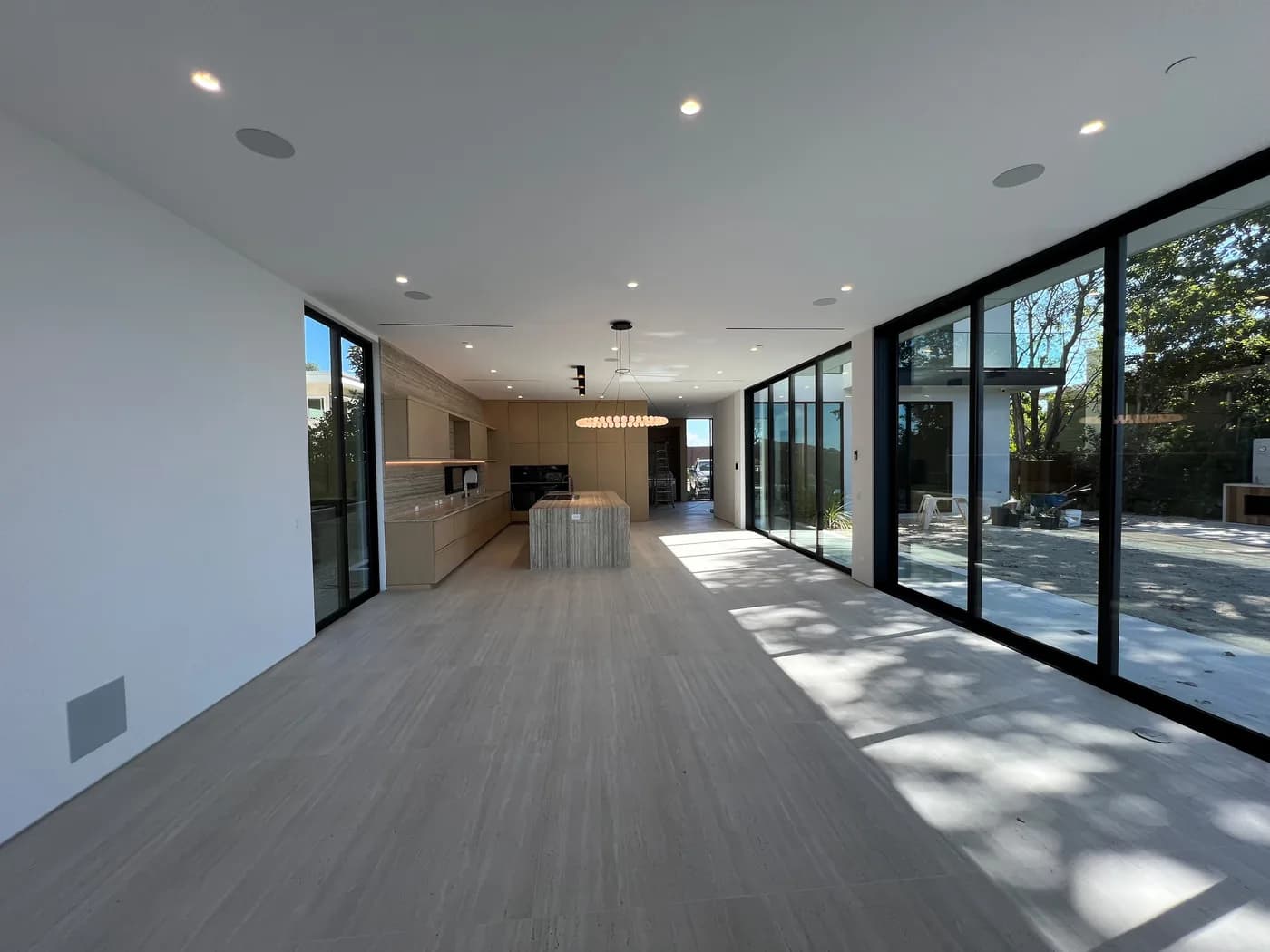 Kitchen with marble island and floor-to-ceiling sliding glass doors to the backyard