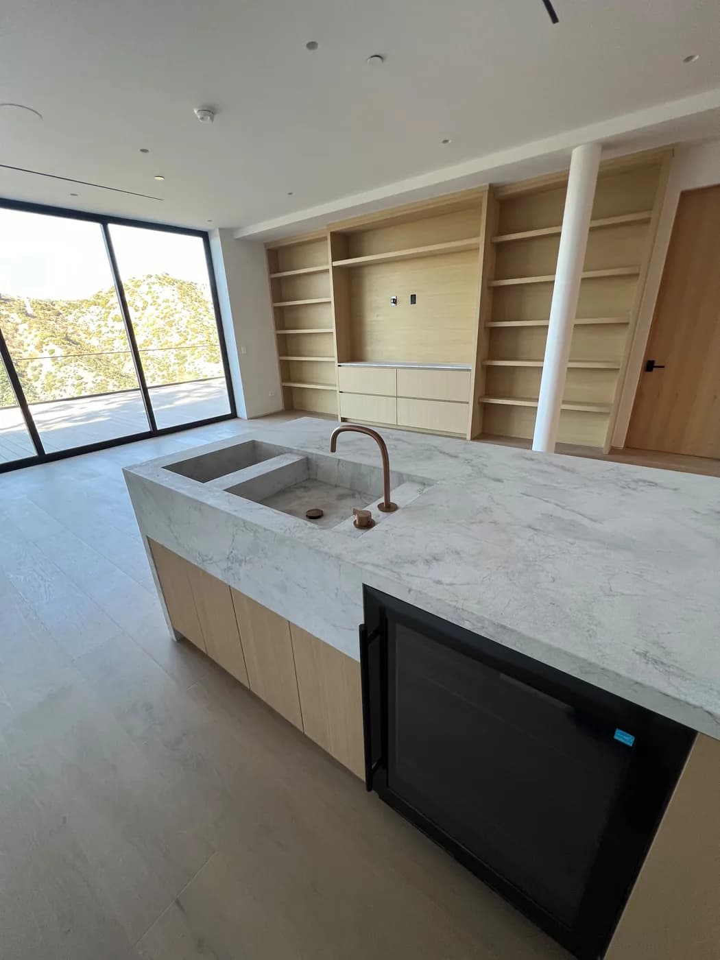 Wet bar with built-in wood shelving and a mountain view through the window